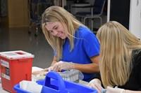 Students practicing with phlebotomy arm